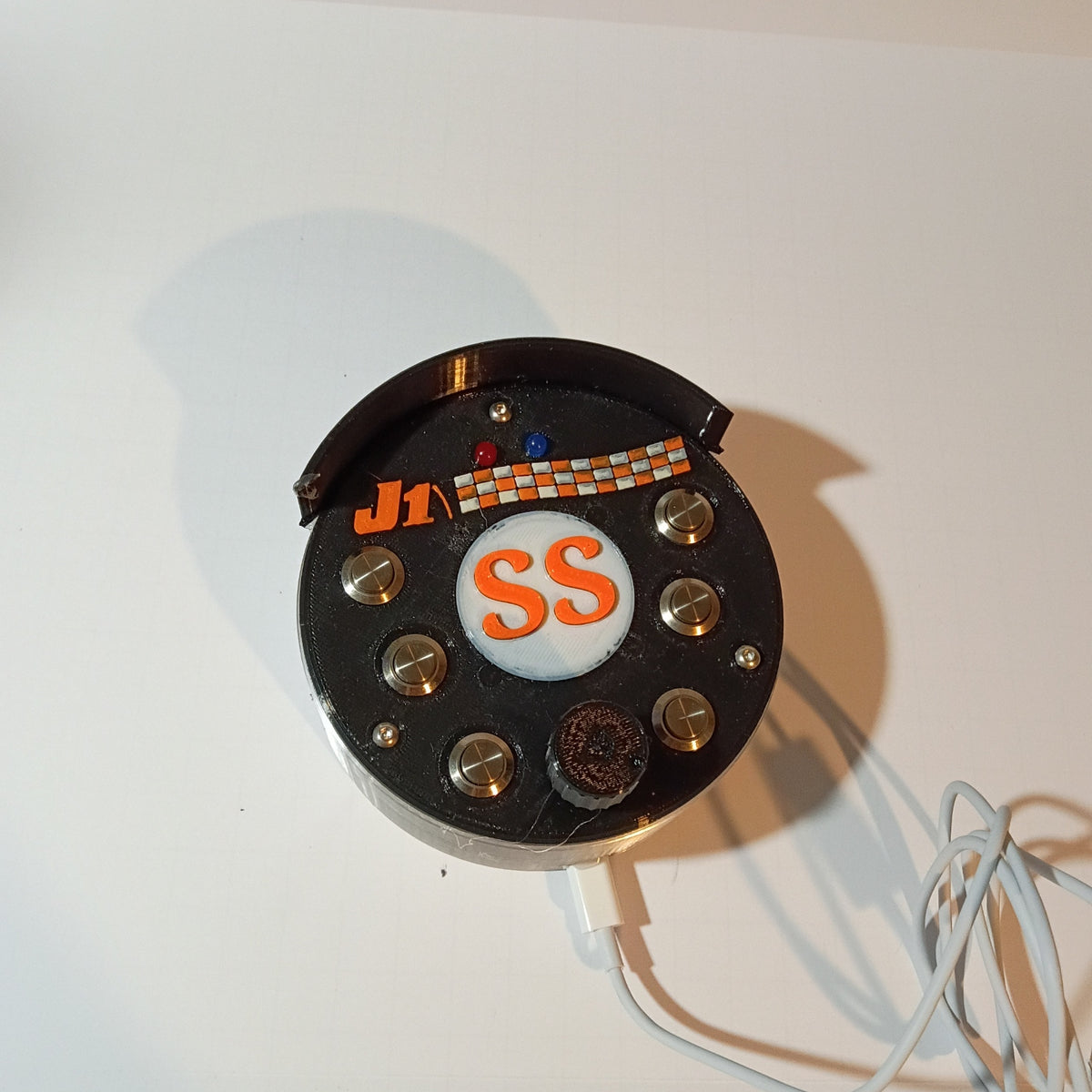 J1 SS black round USB button box photographed on a white backdrop