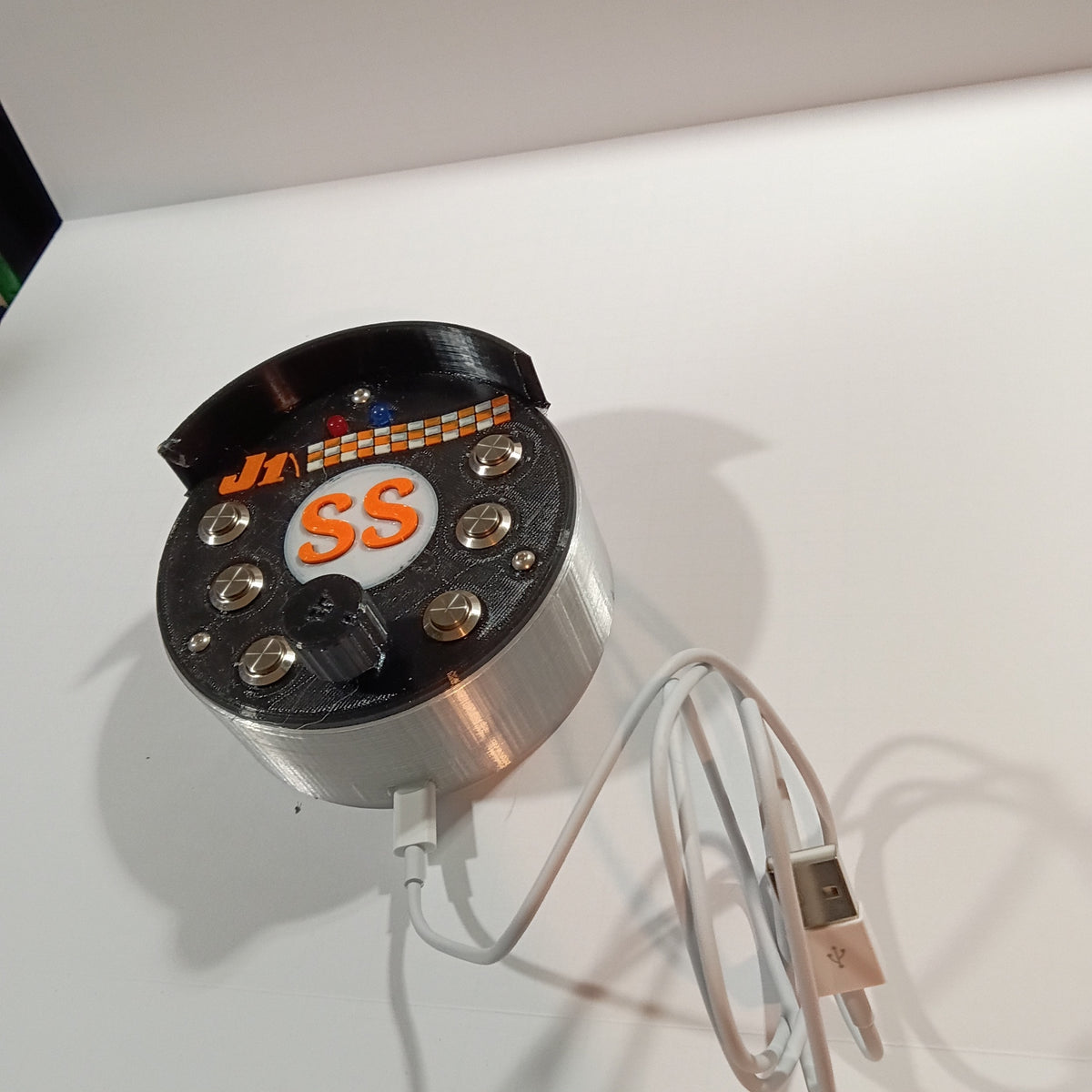 J1 SS black round USB button box photographed on a white backdrop
