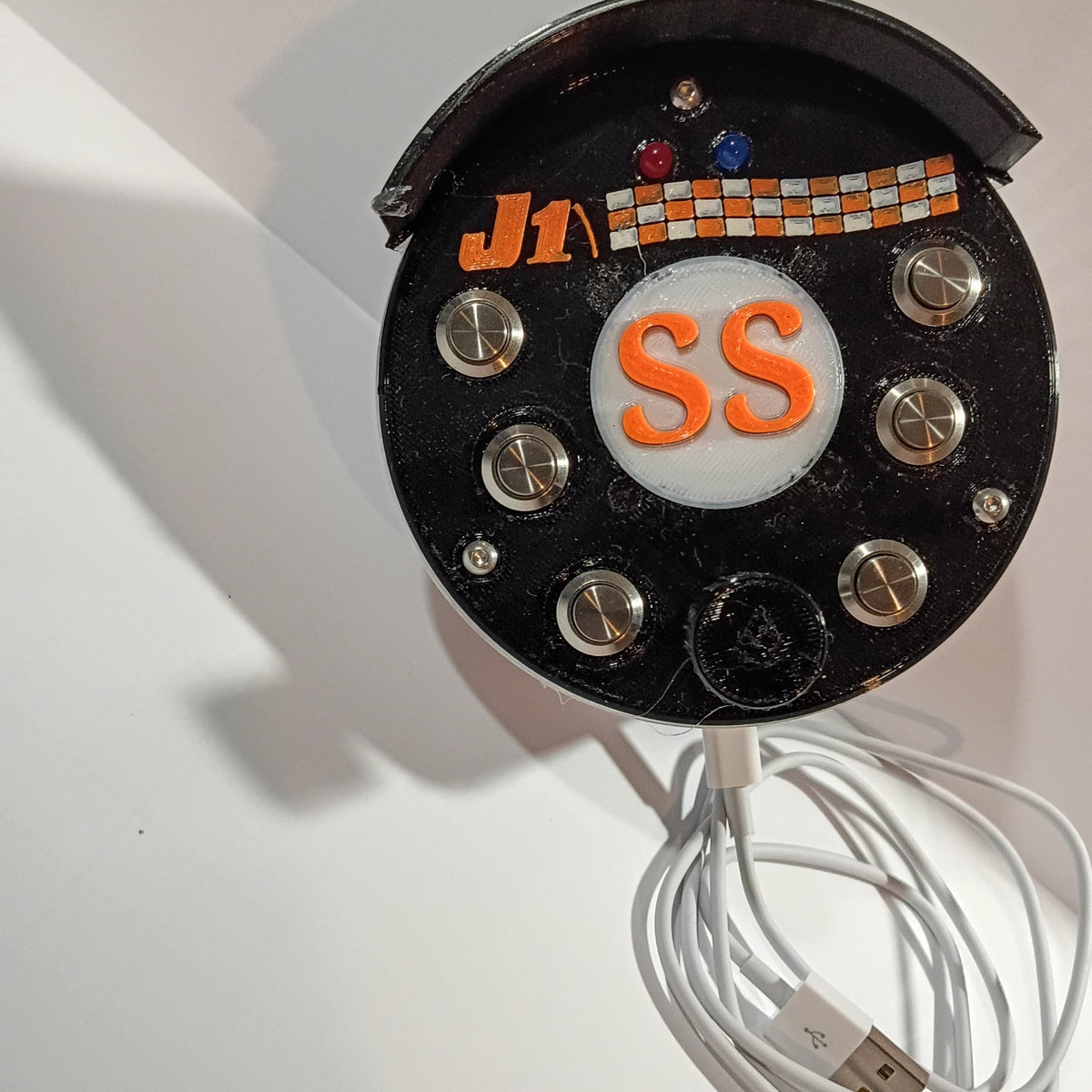 J1 SS black round USB button box photographed on a white backdrop